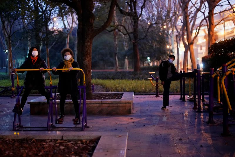 People wearing face masks work out on exercise machines at a park, as the country is hit by an outbreak of the novel coronavirus, in Shanghai