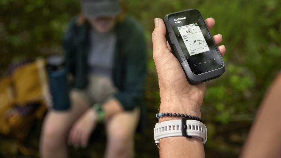 Woman using Garmin eTrex Solar device