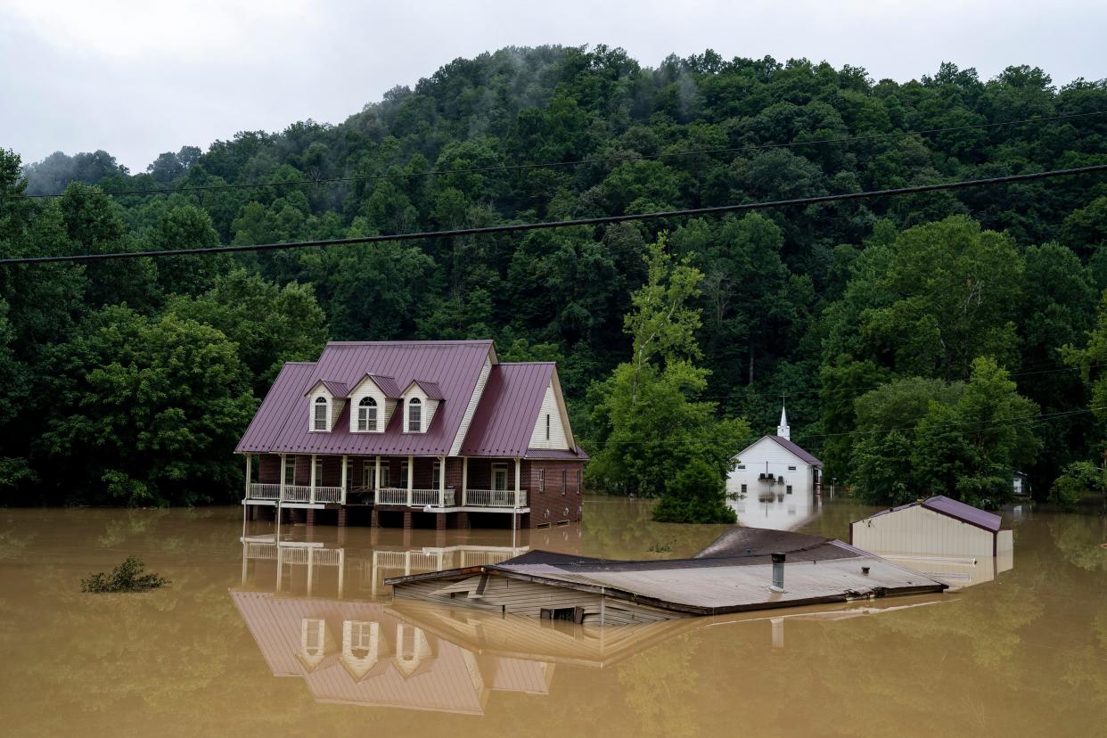 A house is seen almost completely submerged off of the Bert T Combs Mountain Parkway on Friday in Breathitt County, Ky.