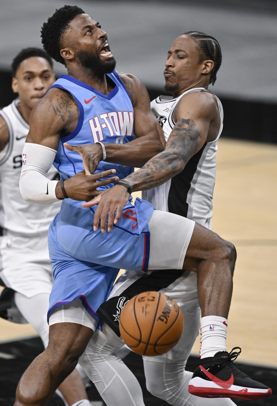 Houston Rockets' David Nwaba, left, is fouled by San Antonio Spurs' DeMar DeRozan during the second half of an NBA basketball game, Saturday, Jan. 16, 2021, in San Antonio. (AP Photo/Darren Abate)