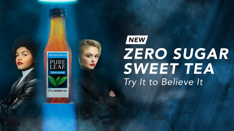 Emily Alyn Lind and Celeste O'Connor posing next to a bottle of Pure Life Zero Sugar Sweet Tea