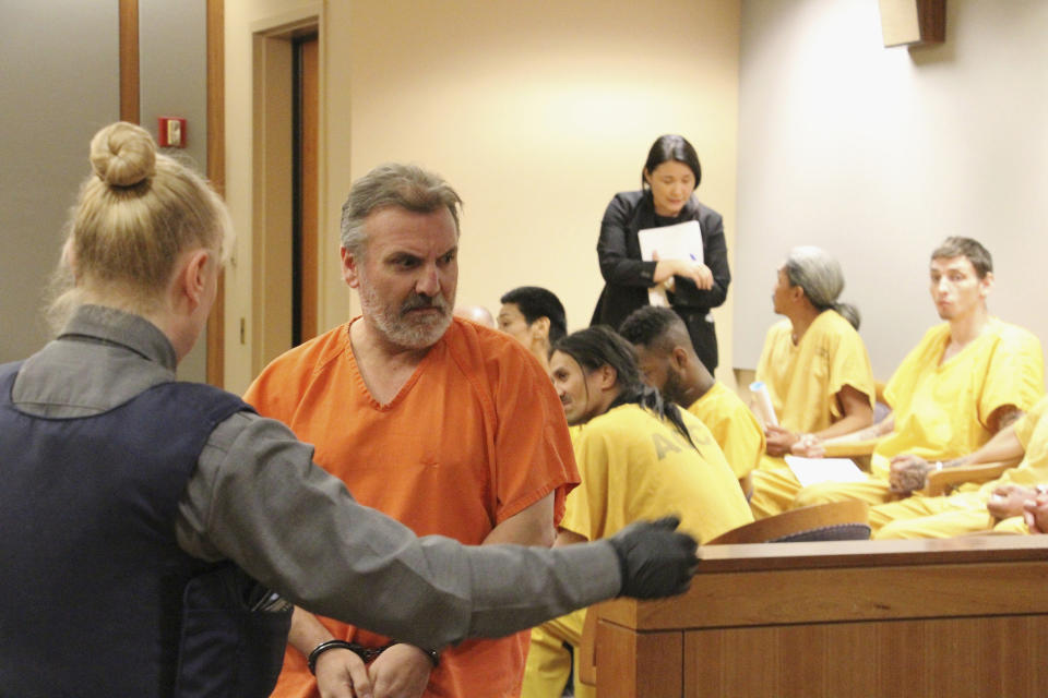 Brian Steven Smith, second from left, is escorted out of a courtroom in Anchorage, Alaska, Monday, Oct. 21, 2019. Smith has pleaded not guilty to 14 charges stemming from the deaths of two Alaska Native women. (AP Photo/Mark Thiessen)