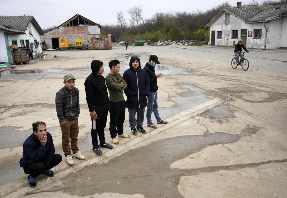 Vietnamese workers who are helping construct the first Chinese car tire factory in Europe stand in front of a barrack near the northern Serbian town of Zrenjanin, 50 kilometers north of Belgrade, Serbia, Thursday, Nov. 18, 2021. Reports have emerged in Serbia of prison-like conditions for some 500 of them at the construction site in north of the country where China's Shandong Linglong Tire Co is building the huge factory. Populist-run Serbia is a key spot for China's expansion and investment policies in Europe and Chinese companies have kept a tight lid on their projects in the country amid reports of disrespect of the Balkan nation's anti-pollution laws and labor regulations. (AP Photo/Darko Vojinovic)