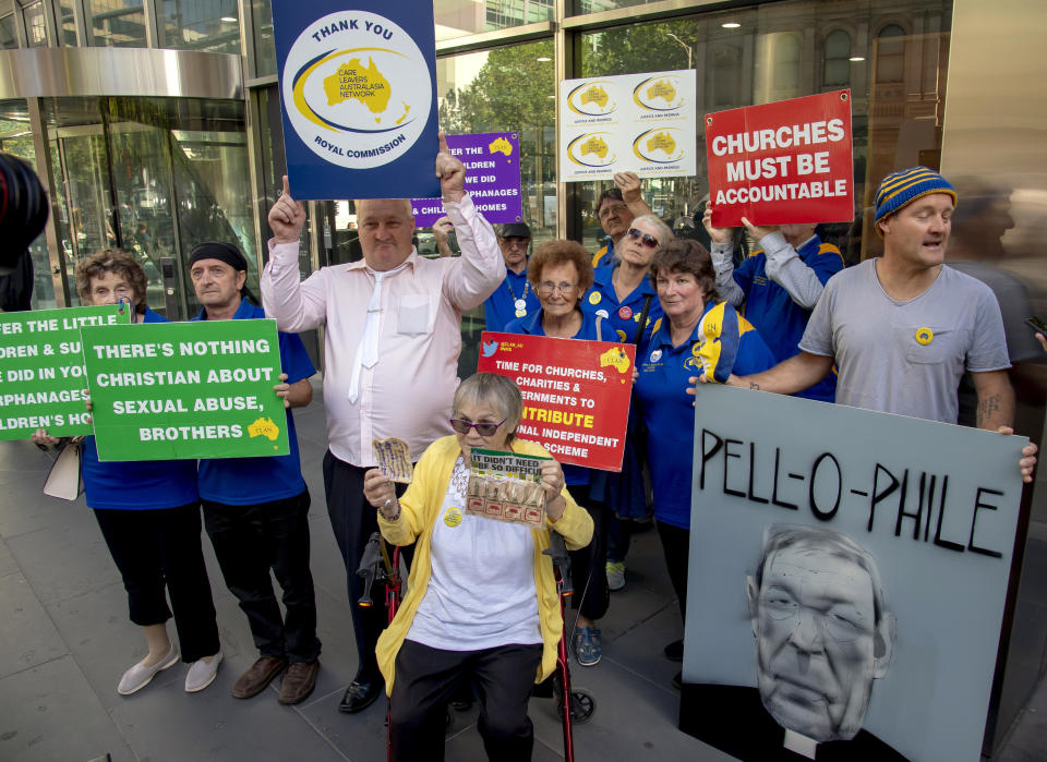 Protesters hold placards outside the County Court where Cardinal George Pell is to arrive in Melbourne, Australia, Wednesday, Feb. 27, 2019. The most senior Catholic cleric ever convicted of child sex abuse faces his first night in custody following a sentencing hearing on Wednesday that will decide his punishment for molesting two choirboys in a Melbourne cathedral two decades ago. (AP Photo/Andy Brownbill)