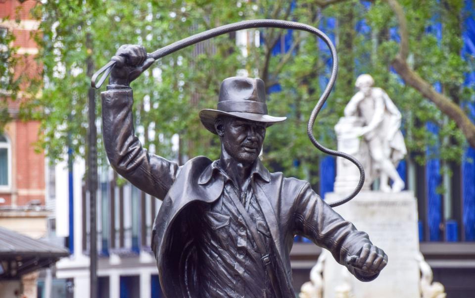 London, UK. 28th June 2023. A new sculpture of Indiana Jones has been unveiled in Leicester Square, part of the permanent statue trail 'Scenes In The Square' featuring famous film characters. The unveiling of the statue coincides with the UK opening of Indiana Jones and the Dial of Destiny. Credit: Vuk Valcic/Alamy Live News