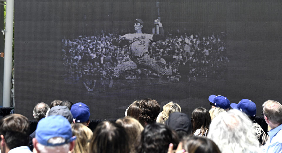 Fans watch a video of Sandy Koufax as the Los Angeles Dodgers unveil a Sandy Koufax statue in the Centerfield Plaza to honor the Hall of Famer and three-time Cy Young Award winner prior to a baseball game between the Cleveland Guardians and the Dodgers at Dodger Stadium in Los Angeles, Saturday, June 18, 2022. (Keith Birmingham/The Orange County Register via AP)