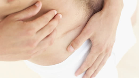 elevated view of a man looking at a scar on his stomach