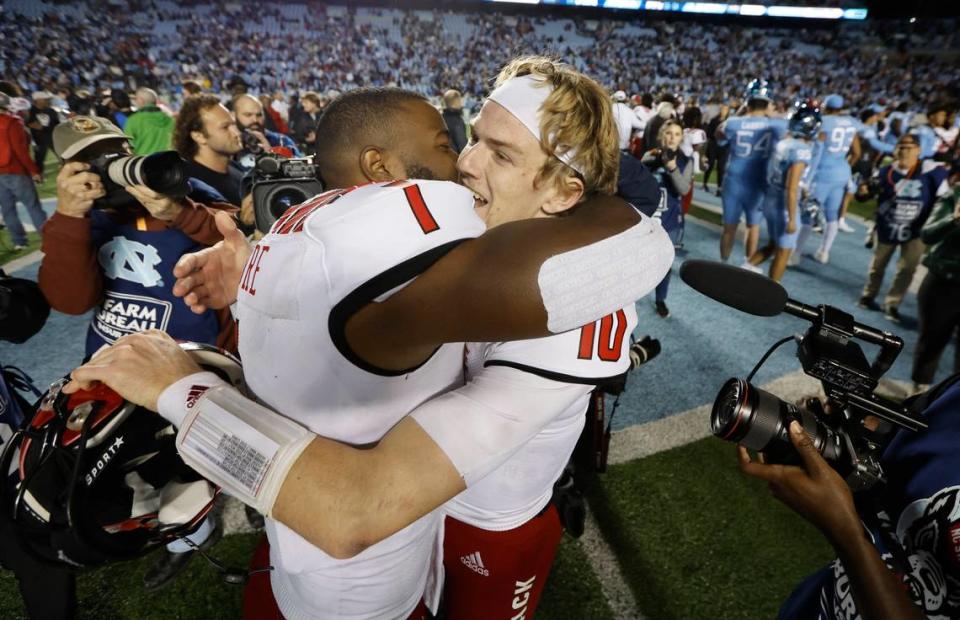 N.C. State linebacker Isaiah Moore (1) and quarterback Ben Finley (10) hug after N.C. State’s 30-27 overtime victory over UNC at Kenan Stadium in Chapel Hill, N.C., Friday, Nov. 25, 2022.