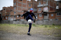 Nicolás Suárez, de 16 años, domina un balón en una cancha de fútbol del barrio de Fraga, en Buenos Aires, Argentina, el sábado 6 de junio de 2020. (AP Foto/Natacha Pisarenko)