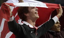 Canada's Derek Drouin wraps himself in the Canadian flag as he celebrates bronze in the men's high jump finals at the Olympic Stadium during the Summer Olympics in London on Tuesday, August 7, 2012. THE CANADIAN PRESS/Sean Kilpatrick