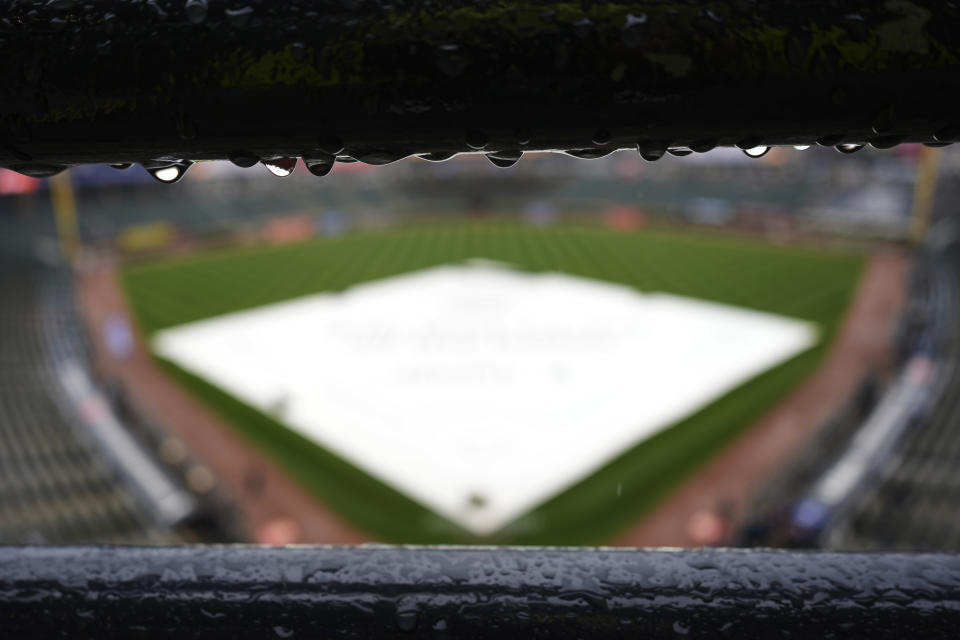 The tarp covers the infield before a baseball game between the Chicago White Sox and the Atlanta Braves was postponed due to rain in Chicago, Wednesday, April 3, 2024. (AP Photo/Nam Y. Huh)