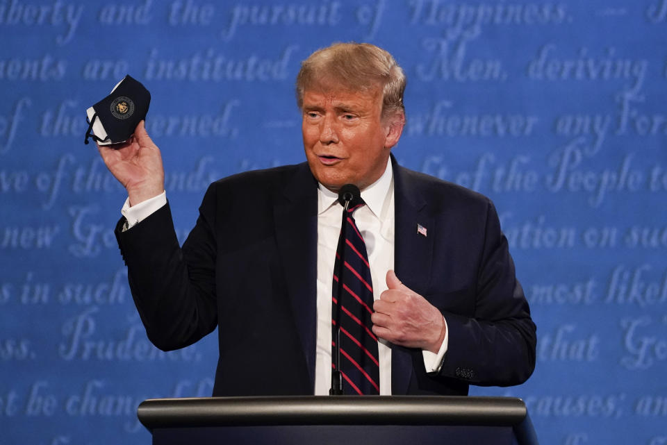 Trump holds up his face mask during the first presidential debate on Tuesday. (Photo: ASSOCIATED PRESS)
