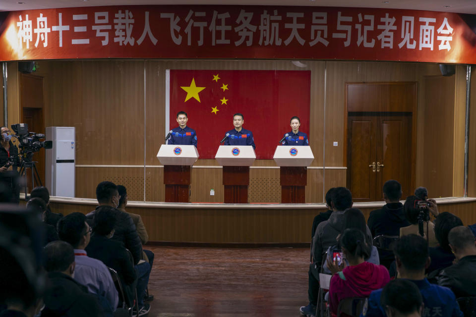 In this photo released by Xinhua News Agency, Chinese astronauts, from left, Ye Guangfu, Zhai Zhigang and Wang Yaping meet the reporters at a press conference at the Jiuquan Satellite Launch Center ahead of the Shenzhou-13 launch mission from Jiuquan in northwestern China, Thursday, Oct. 14, 2021. China is preparing to send three astronauts to live on its space station for six months — a new milestone for a program that has advanced rapidly in recent years. (Ju Zhenhua/Xinhua via AP)