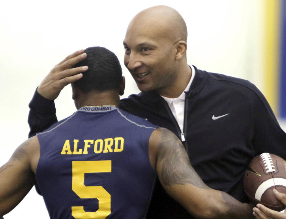 FILE - In this March 13, 2015 file photo, then-West Virginia assistant coach Lonnie Galloway, right, congratulates Mario Alford during NFL Football Pro Day, in Morgantown, W.Va. On Friday, Dec. 16, 2016, Louisville announced it has suspended Galloway for the Citrus Bowl following a review of how the co-offensive coordinator handled Wake Forest game plans he received from former Demon Deacons broadcaster Tommy Elrod. (AP Photo/Raymond Thompson, File)