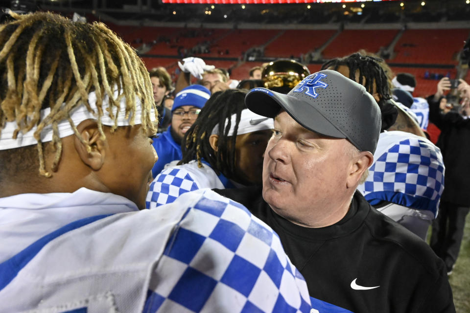 Kentucky head coach Mark Stoops, right, congratulates defensive back Carrington Valentine after their victory over Louisville in an NCAA college football game in Louisville, Ky., Saturday, Nov. 27, 2021. (AP Photo/Timothy D. Easley)