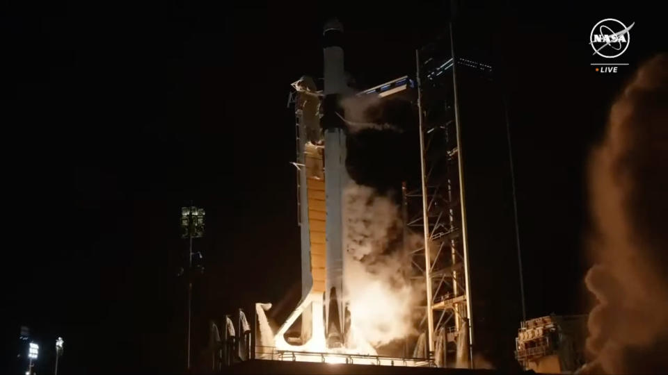 Ένας ασπρόμαυρος πύραυλος Falcon 9 της SpaceX απογειώνεται στον νυχτερινό ουρανό.