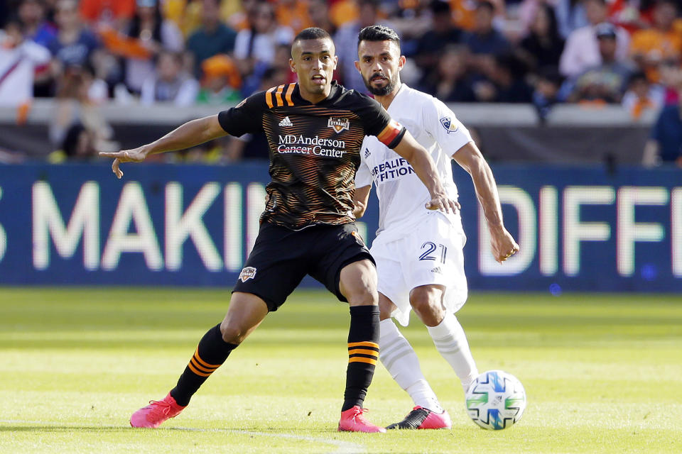 Houston Dynamo forward Mauro Manotas, left, moves the ball in front of Los Angeles Galaxy defender Giancarlo Gonzalez (21) during the second half of an MLS soccer match Saturday, Feb. 29, 2020, in Houston. (AP Photo/Michael Wyke)