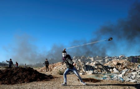 A Palestinian uses a sling to hurl stones during clashes with Israeli troops near the Jewish settlement of Beit El, near Ramallah, in the Israeli-occupied West Bank December 14, 2018. REUTERS/Mohamad Torokman