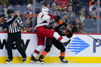 Carolina Hurricanes' Brendan Smith, center, collides with Philadelphia Flyers' Scott Laughton during the second period of an NHL hockey game, Friday, Nov. 26, 2021, in Philadelphia. (AP Photo/Matt Slocum)