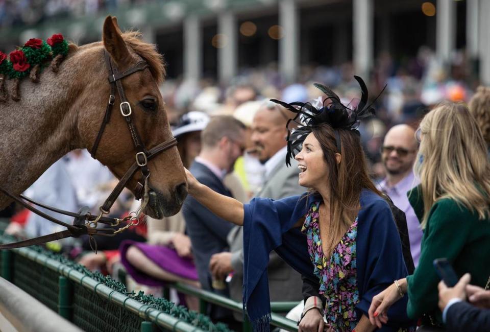 Kacee Barrett of Brainerd, Minn., pets one of the outrider horses before an undercard race on Derby Day last year.