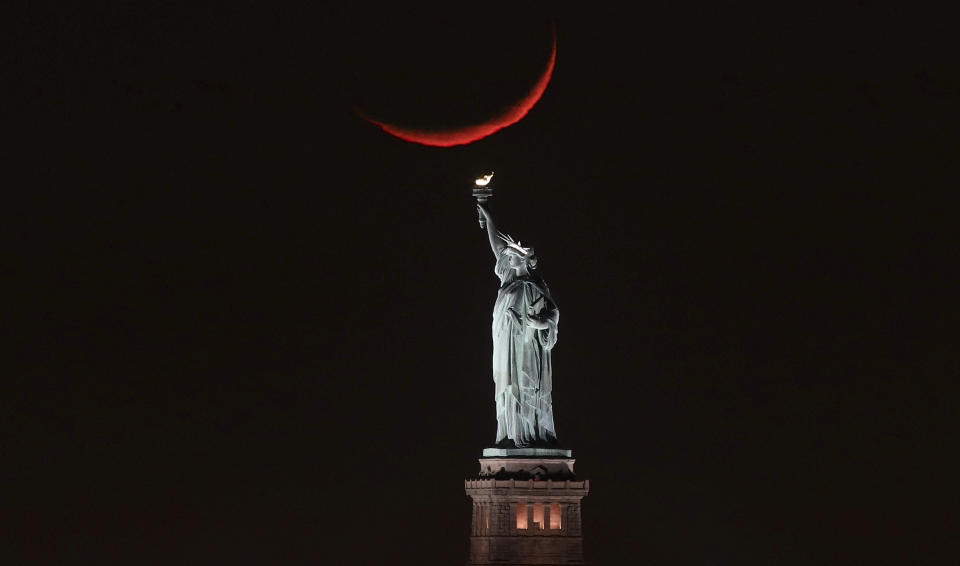 A crescent moon sets behind the Statue of Liberty on Jan. 19, 2018 in New York City. (Photo: Gary Hershorn via Getty Images)