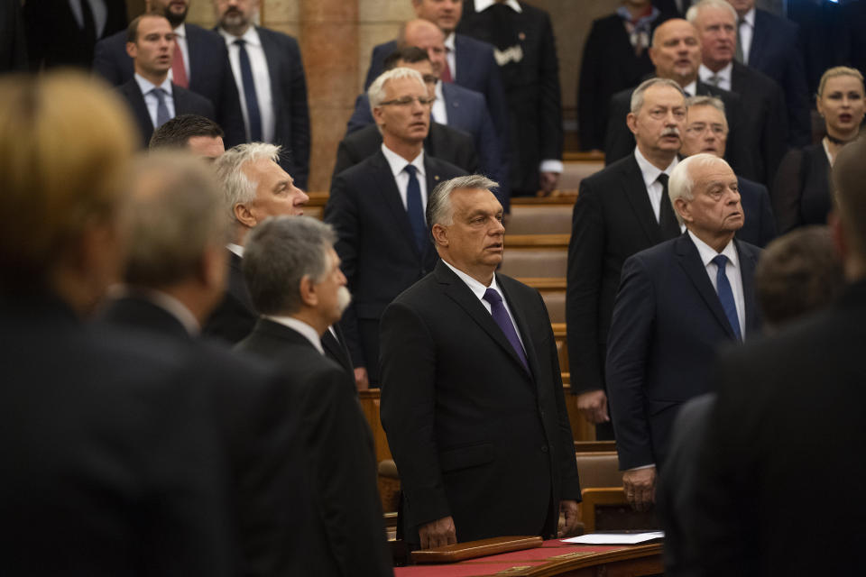 Hungarian Prime Minister Viktor Orban, centre, and lawmakers sing the national anthem during the commemorative parliamentary session marking the centenary of the Trianon Peace Treaty in Budapest, Hungary, 04 June 2020. Hungary is commemorating the 100th anniversary of a post-World War I peace treaty which led to the loss of about two-thirds of its territory and left some 3.3 million Hungarians outside the country's new borders. (Tibor Illyes/MTI via AP)