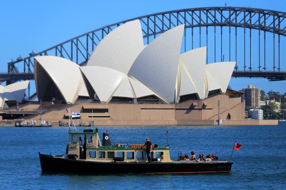 Dancers from Handa Opera's production of La Traviata sail past the Sydney Opera House as they arrive by boat for a rehearsal at an over-water stage at Mrs Macquaries Chair, ahead of the launch of new shows later this month in Sydney on March 15, 2021. (Photo by Steven Saphore / AFP) (Photo by STEVEN SAPHORE/AFP via Getty Images)