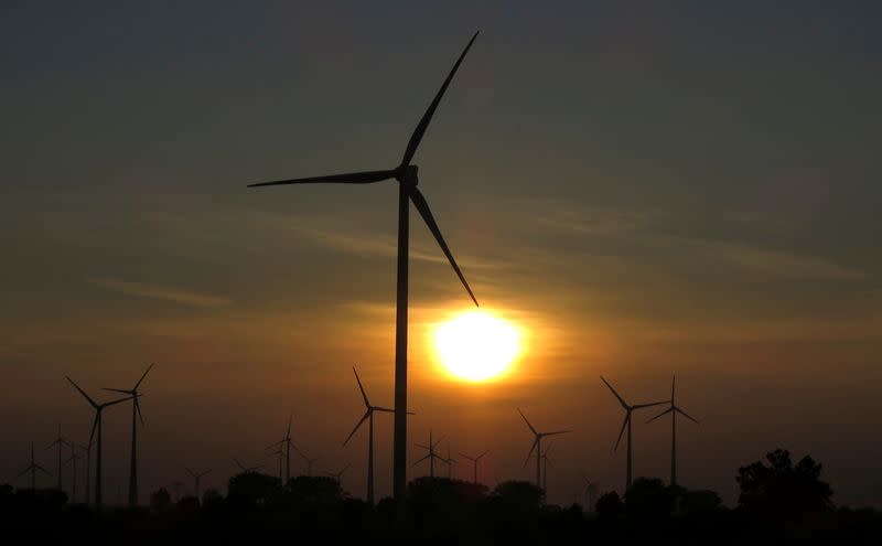 FILE PHOTO: The sun sets behind power-generating wind turbines from a wind farm near the village of Ludwigsburg