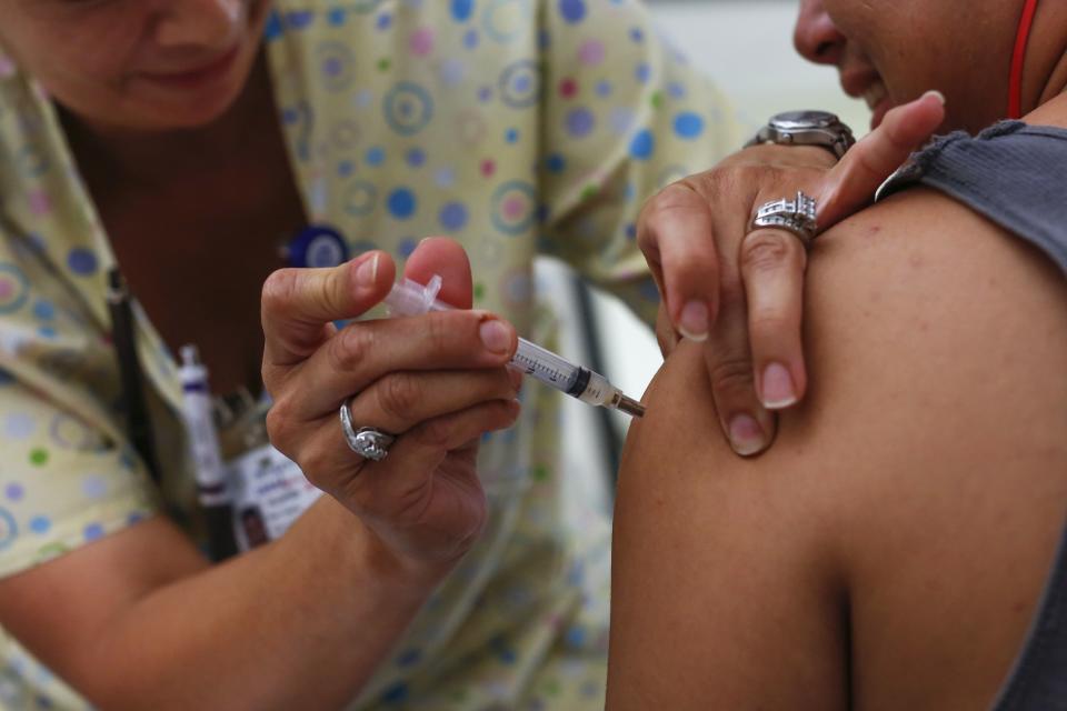 A teenager receives a tetanus vaccination at the Remote Area Medical and Operation Lone Star joint health clinic at Palmview High School in Mission, Texas August 5, 2014. Operation Lone Star started 16 years ago to help the guard prepare for emergencies such as hurricanes or pandemics in south Texas. Since then it has expanded its medical care component, treating thousands in a region that hugs the Mexican border, including some who come because no identification papers are required. Picture taken August 5, 2014. REUTERS/Shannon Stapleton (UNITED STATES - Tags: SOCIETY HEALTH POLITICS)