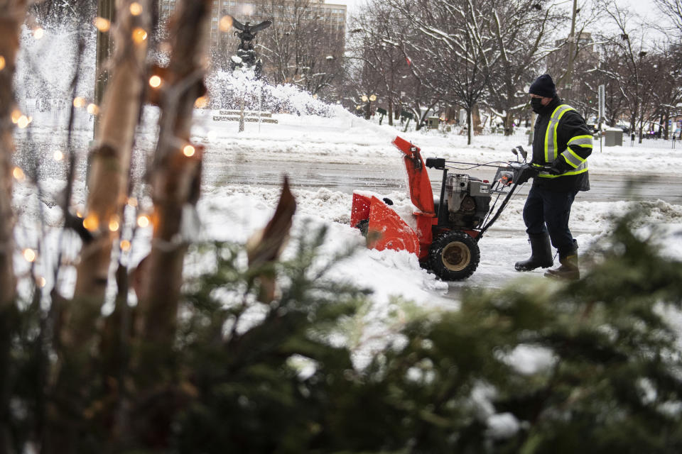 A worker operates a snowblower outside a hotel in Ottawa, as a winter storm warning is in effect, on Friday, Dec. 23, 2022. (Justin Tang /The Canadian Press via AP)