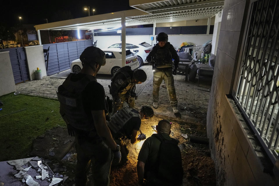 Israeli police officers inspect a damaged house after it was hit by a rocket fired from the Gaza Strip, in Sderot, Israel, Wednesday, May 10, 2023. (AP Photo/Ohad Zwigenberg)