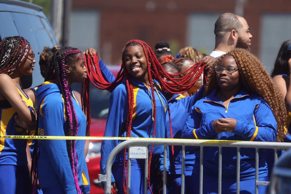 Zavi Motley, with the Crusaders Marching Unit, laughs as teammates hold up her hair while waiting to join the Juneteenth parade in Buffalo.