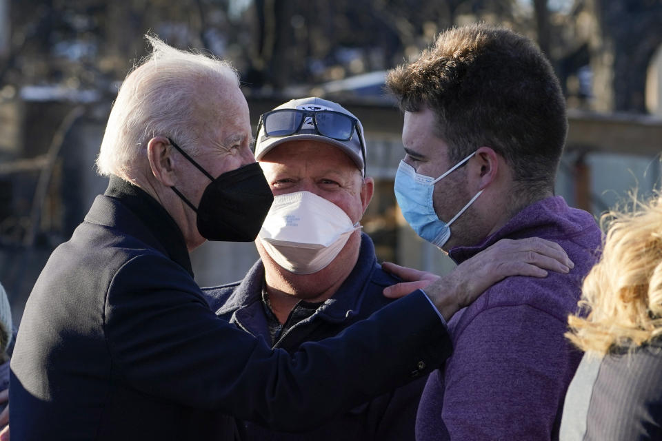 FILE - President Joe Biden talks with people as he tours a neighborhood in Louisville, Colo., Friday, Jan. 7, 2022, that was impacted by the recent wildfire. (AP Photo/Susan Walsh, File)