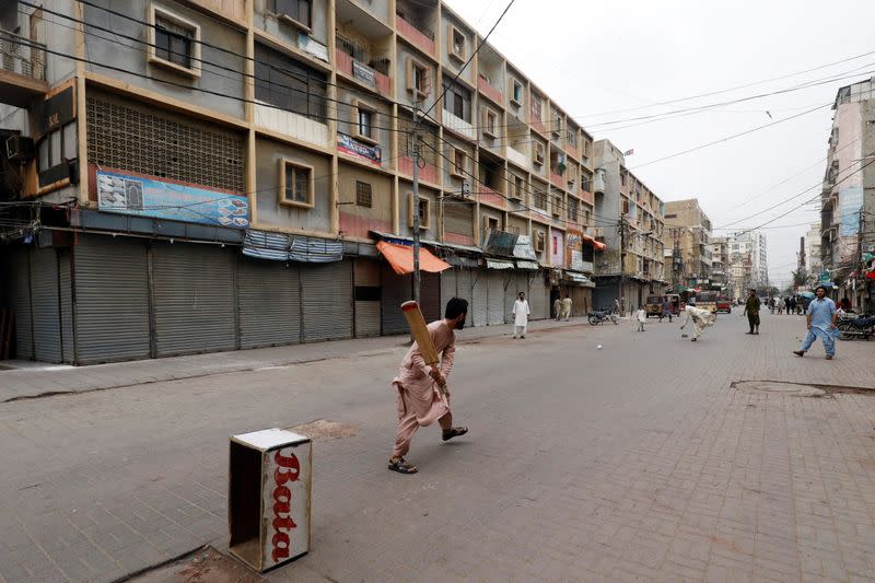 Shopkeepers play cricket along closed market amid the COVID-19 outbreak in Karachi