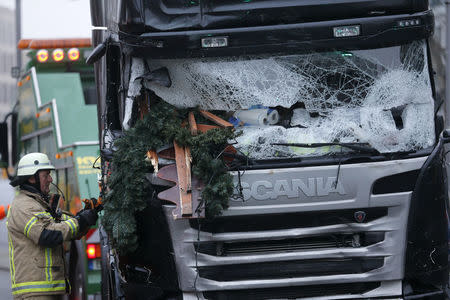 A fire fighter stands beside the truck which ploughed last night into a crowded Christmas market in the German capital Berlin, Germany, December 20, 2016. REUTERS/Hannibal Hanschke