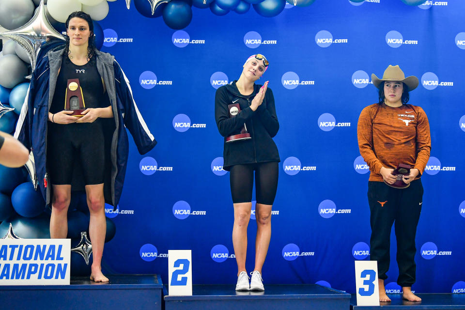 University of Pennsylvania swimmer Lia Thomas accepts the winning trophy for the 500 Freestyle finals as second place finisher Emma Weyant and third place finisher Erica Sullivan watch during the NCAA Swimming and Diving Championships on March 17, 2022, in Atlanta. (Rich von Biberstein / Icon Sportswire via Getty Images)