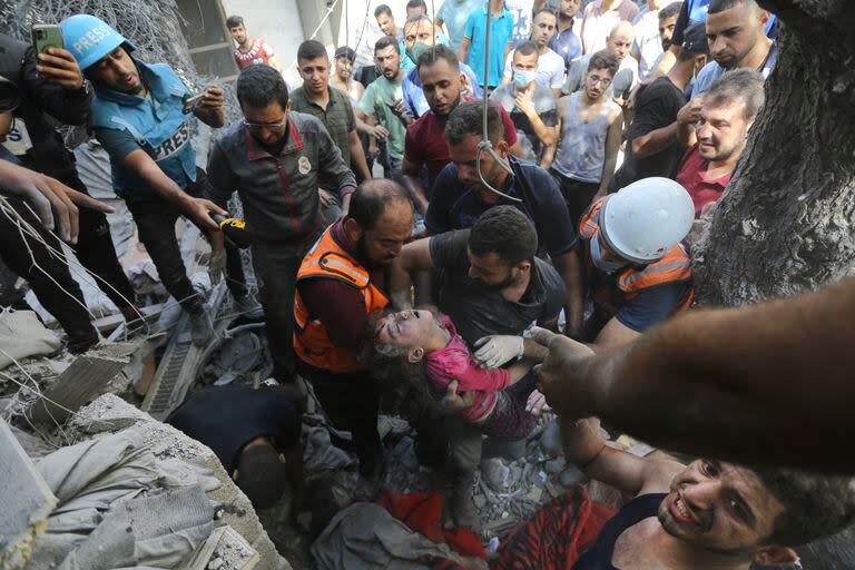 Palestinos rescatan a un niño de entre los escombros tras los ataques aéreos israelíes en Ciudad de Gaza, Franja de Gaza, miércoles 18 de octubre de 2023
