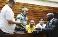 (L-R) Baktash Akasha, Gulam Hussein, Ibrahim Akasha and Vijaygiri Goswami are briefed by their lawyer Cliff Ombeta at Mombasa Law Courts during a court appearance on drug-related charges in Mombasa February 17, 2015. REUTERS/Joseph Okanga