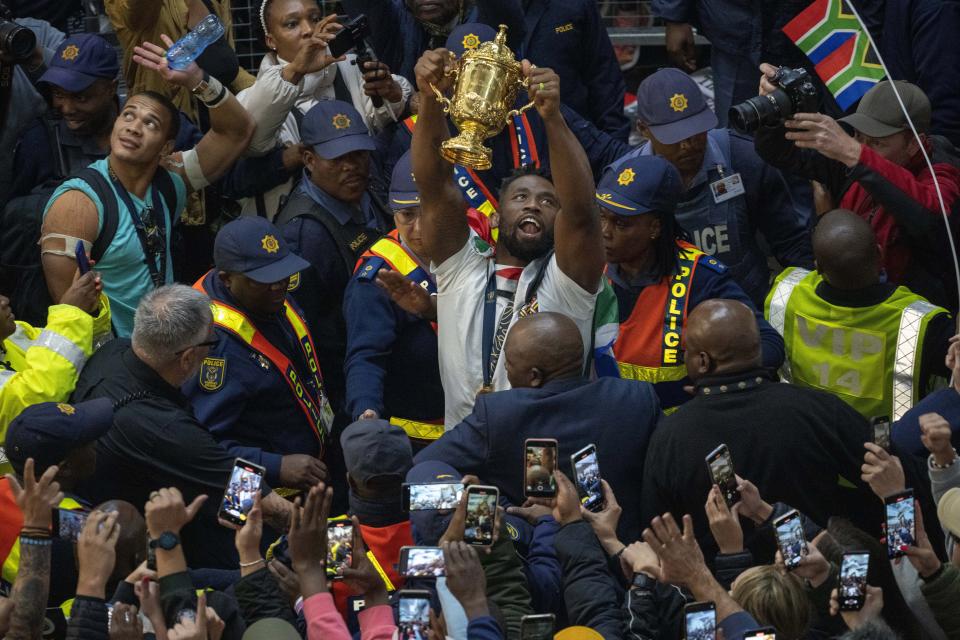 South Africa' Springbok captain Siya Kolisi holds the Webb Ellis cup after arriving with other players at O.R Tambo's international airport in Johannesburg, South Africa, Tuesday Oct. 31, 2023, after the Rugby World Cup. (AP Photo/Jerome Delay)