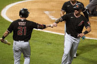 Arizona Diamondbacks' David Peralta, right, bumps fists with Stephen Vogt after Peralta score on a single from Nick Ahmed during the second inning of a baseball game against the Los Angeles Angels Wednesday, Sept. 16, 2020, in Anaheim, Calif. (AP Photo/Marcio Jose Sanchez)