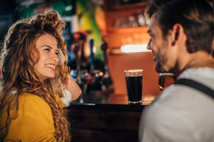 Young couple drinking beer in pub