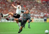 FILE - In this June 26, 1996 file photo England's Teddy Sheringham is sent flying by Germany's Stefan Reuter, left, during the European Soccer Championships semi-final match against England at London's Wembley Stadium. Germany won 6-5 on penalties after the match finished 1-1 following extra time. (AP Photo/Lynne Sladky, File)