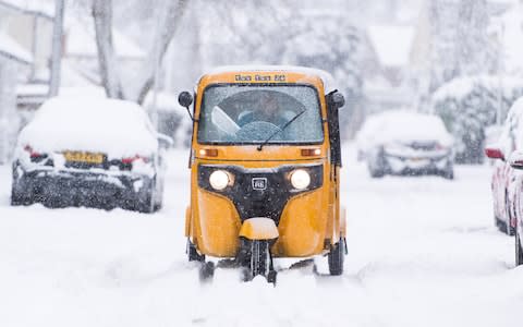  A yellow tuk tuk in the snow in the village of Redbourn, Hertfordshire - Credit: Polly Thomas/REX/Shutterstock