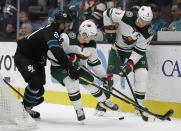 San Jose Sharks' Brandon Davidson, left, fights for the puck with Minnesota Wild forward Ryan Donato (6) and Mikko Koivu, right, in the second period of an NHL hockey game Thursday, March 5, 2020, in San Jose, Calif. (AP Photo/Ben Margot)