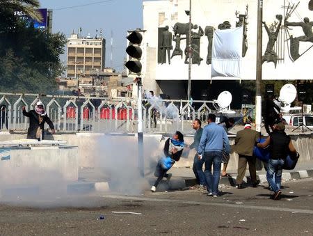 Protesters run from tear gas fired by security forces after supporters of Iraqi Shi'ite cleric Moqtada al-Sadr tried to approach the heavily fortified Green Zone during a protest at Tahrir Square in Baghdad, Iraq February 11, 2017. REUTERS /Mahmoud Raouf Mahmoud