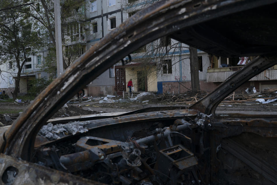 A woman enters a residential building which was heavily damaged after a Russian attack last week in Zaporizhzhia, Ukraine, Sunday, Oct. 16, 2022. (AP Photo/Leo Correa)