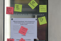 Adhesive notes are shown after they were left on the doors of Seattle Police Headquarters, Monday, July 13, 2020, following a news conference held by Mayor Jenny Durkan. Durkan and Police Chief Carmen Best spoke critically of a plan backed by several city council members that seeks to cut the police department's budget by 50 percent. (AP Photo/Ted S. Warren)