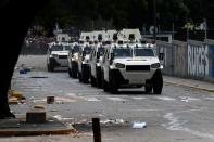 Carros blindados de la Guardia Nacional arriban al barrio Los Ruices en Caracas, Venezuela, el jueves 6 de marzo de 2014. Un agente de la Guardia Nacional y un civil murieron baleados el jueves en medio de un violento enfrentamiento entre vecinos y grupos de motorizados armados que intentaban levantar una barricada en una calle de esa localidad. (AP foto/Fernando Llano)