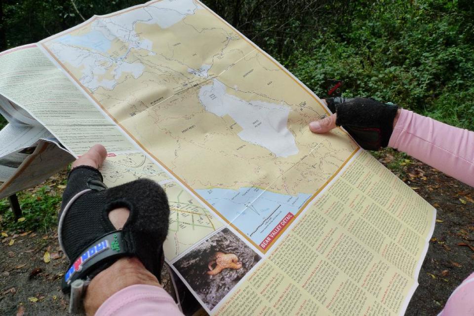 This October 2011 photo shows Timothy McCarthy, of Berkeley, Calif., consulting a trail map at Point Reyes National Seashore in Marin County, Calif., north of San Francisco, as part of a series of bicycle excursions in Northern California. This part of the tour included a hiking and mountain bike jaunt along some of the park’s many trails. (AP Photo/Paula Froke)