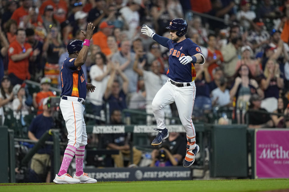 Houston Astros' Alex Bregman, right, celebrates with third base coach Gary Pettis after hitting a home run against the Detroit Tigers during the fifth inning of a baseball game Sunday, May 8, 2022, in Houston. (AP Photo/David J. Phillip)